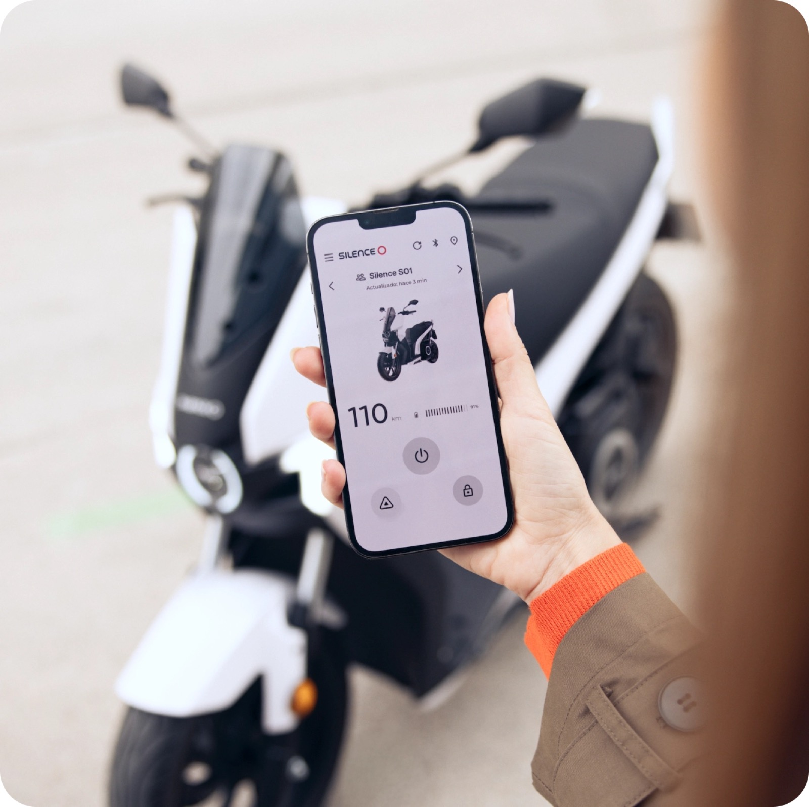 Persona desbloqueando una moto Silence desde la app en su teléfono, en la calle